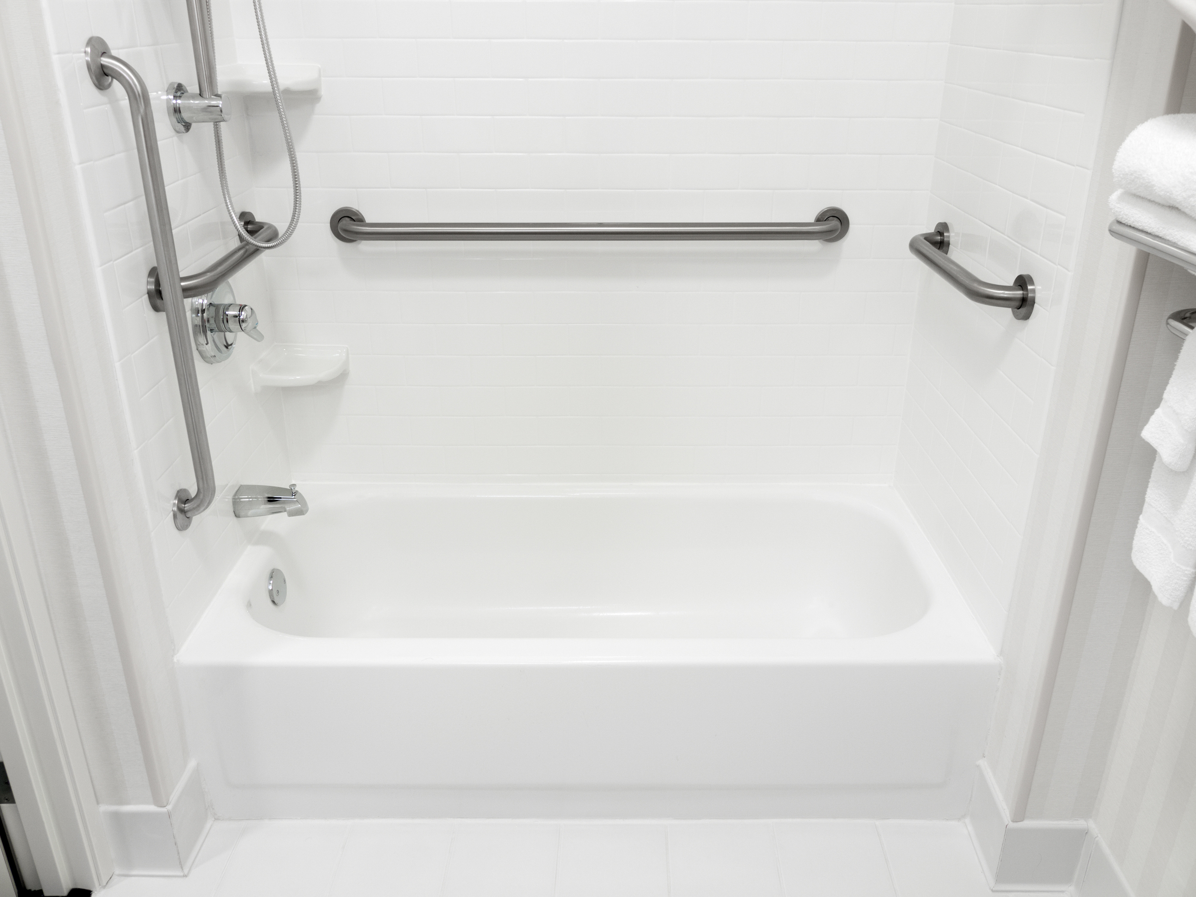 white bathtub with safety rails