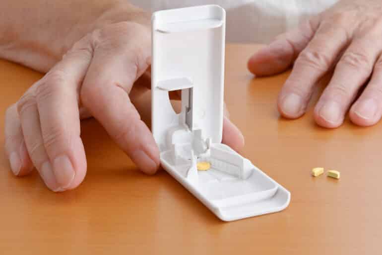 person using a pill cutter