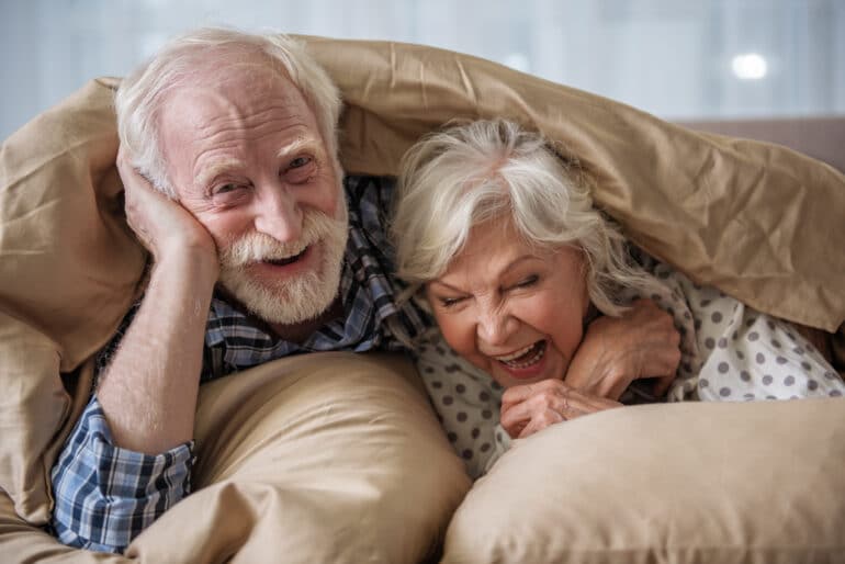 Elderly Couple under a blanket.