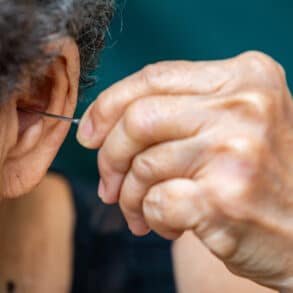 Elderly using ear pick to remove earwax