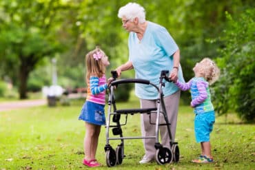 old woman with walker talking to her grandchildren
