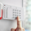 person pressing numbers on a mounted door alarm
