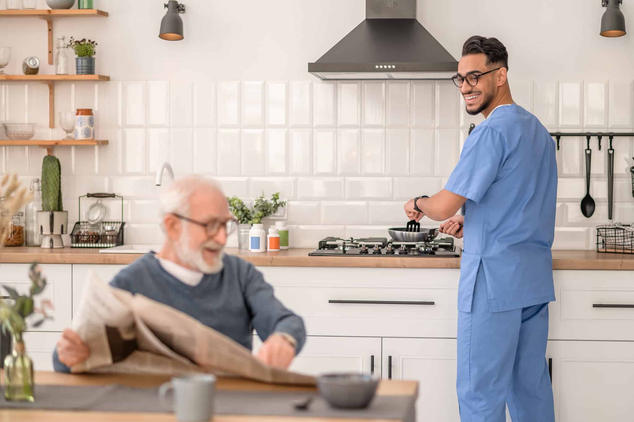 senior with male nurse cooking